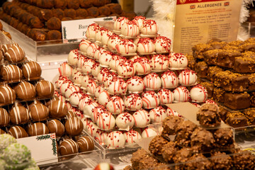 Pyramids of colorful assorted chocolates are neatly displayed on a market