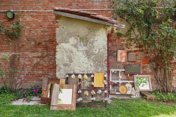 Still life composition displaying various eclectic items and art pieces against a brick wall