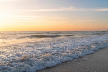 Obraz premium Stunning golden sunset illuminates foamy ocean waves rolling onto sandy beach