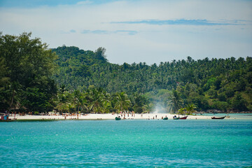 Tropical vacation destination. Mountains, turquoise sea and luxury resorts on the coast of the island. Small palm tree and beautiful calm lagoon on Malibu Beach, Koh Phangan, Thailand.