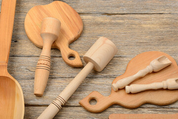 Wooden kitchen tools and cutting boards arranged on rustic wooden surface