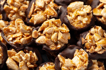 Chocolate Florentines cookies with almonds on a stone board.