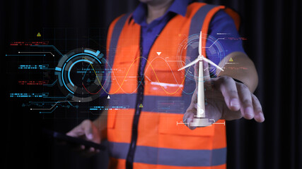 Engineer touching virtual wind turbine hologram. Sustainable renewable energy technology and green power generation concept for future industrial environment and clean electricity.