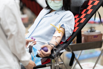 Close-up of a donor’s arm during blood donation on donor chair at blood donation center.Donation for emergency surgery and blood bank unit.Save life and medical treatment concept.