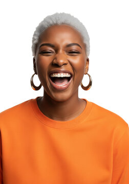 A young black woman with striking metallic platinum hair and a blaze orange shirt laughs joyfully, captured in a high-key professional studio against a transparent cyclorama; confident celebration of