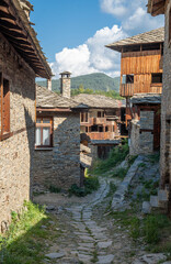 A narrow stone street between old, historic houses in the village of Kovachevitsa in the Rhodope Mountains, Bulgaria