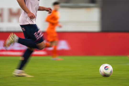 Football player runs with ball during match - blurred motion due to long exposure