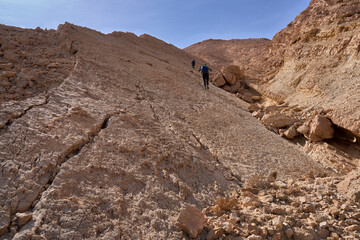Unique landscape in Eilat Mountains nature reserve, the southern Negev. The Israel Trail passes through the reserve. A group of hikers in a hiking trail. A steep ascent to Avrona Cliffs.