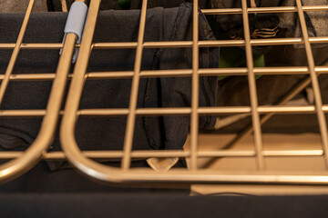 Close-up view of clothes drying on a golden drying rack, showcasing neatly folded garments. Ideal for home decor, lifestyle articles, or advice on laundry organization.