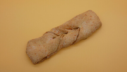 Twisted bread roll resting on a plain background