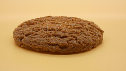 Soft cookie placed on a simple yellow background with a smooth surface to emphasize its texture and shape