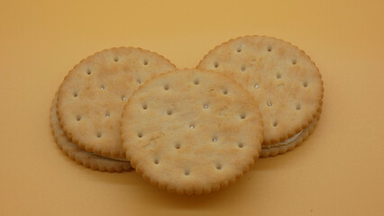 Three round sandwich cookies with cream filling on a light background during a simple food display