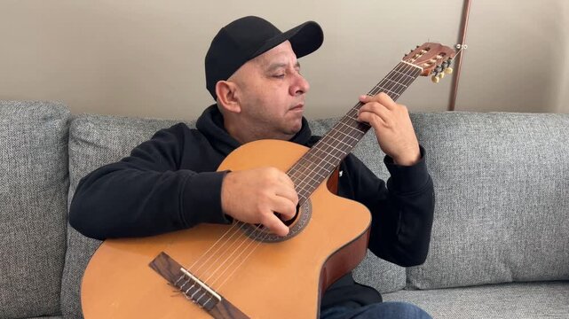 Hombre tocando guitarra espa&ntilde;ola en plano medio horizontal