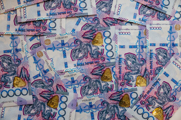 10,000-tenge banknotes are laid out on the table