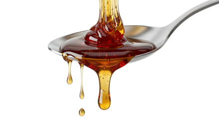 Golden honey pouring and dripping on silver spoon