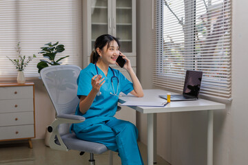 Healthcare professional providing virtual medical support, smiling while talking on phone and working with laptop for telemedicine