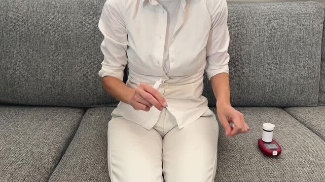 Enfermera preparando lanceta en dispositivo de punci&oacute;n