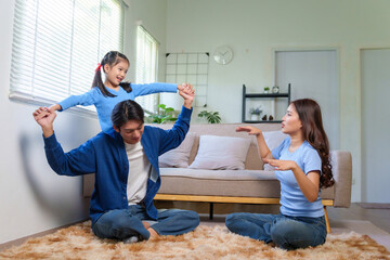 Asian family communicating happily at home, educating daughter with sign language for a hearing impaired child