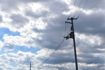 Power lines and poles on a cloudy day.