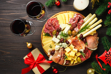 Antipasto platter with jamon, salami and cheese assortment with christmas decorations.
