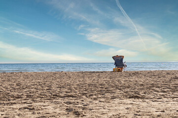 YOUNG GIRL SITTING IN A BEACH CHAIR LOOKING AT THE HORIZON, LISA BEACH, SANTA POLA, ALICANTE, SPAIN