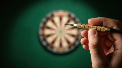 Hand holding brass dart with blurred dartboard background, aiming for target with focus and precision in game play