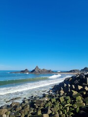 Picturesque emerald Basque coast along Bay of Biscay with rocky islands on shelf and piercing blue water of Bay of Biscay.  Biscay, Basque Country, Spain