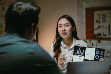 Young businesswoman sharing a data analysis report on a digital tablet with a colleague during an important office meeting