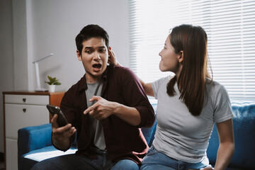 Man finding shocking content on a mobile phone, showing it to his surprised girlfriend, discussing relationship problems
