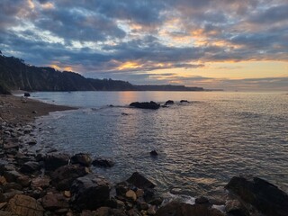 Fototapeta premium Panoramic view from the top of the cliffs at the north atlantic coastline of Spain at sunset with misty atmosphere 
