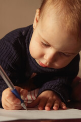 A toddler fully absorbed in the process of learning.