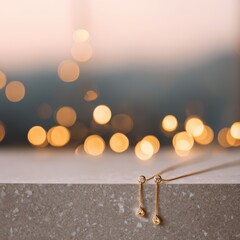 Gold drop earrings with clear gemstones on textured surface with bokeh lights