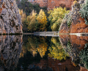 Monasterio de Piedra lake reflecting autumn trees and rock formations