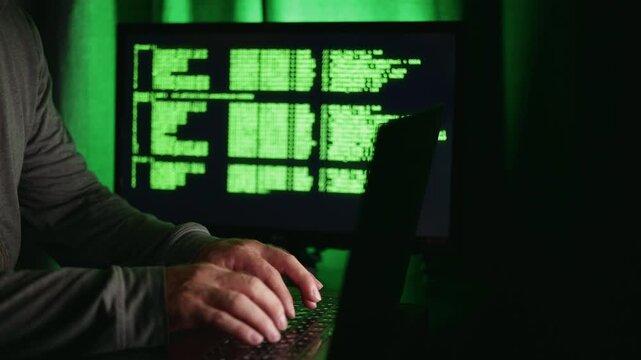 Silent hacker activity, Hidden figure types secret code, Stealthy individual inputs covert commands silently, Secret operator discreetly entering encrypted information under cover of darkness concept