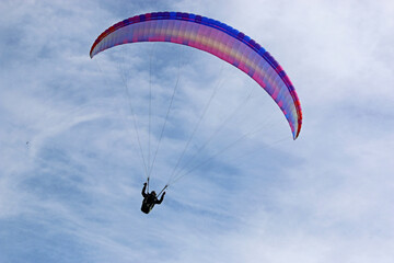 Paraglider flying in a blue sky	