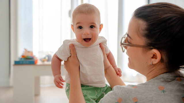 Joyful baby with mother enjoying family moments at home