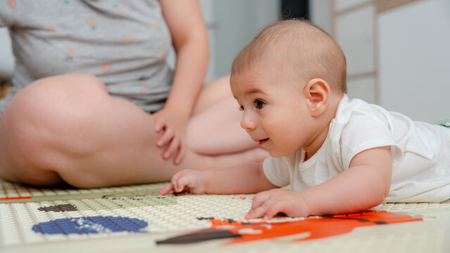 Baby exploring the playmat with family at home