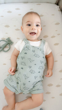 Happy baby smiling in green dinosaur romper