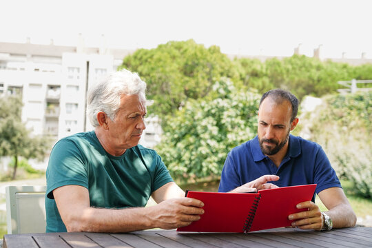 Friends reviewing a photo album in a park setting
