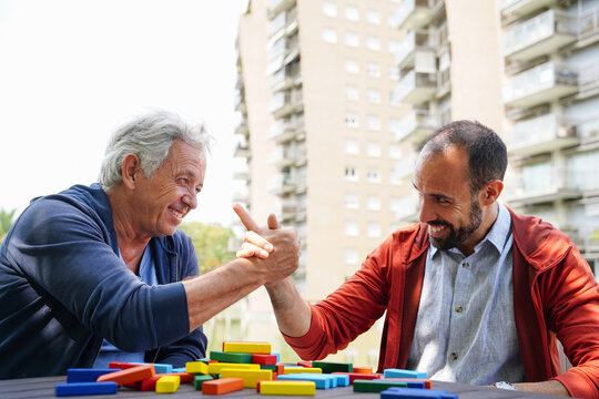 Two friends enjoying a game of arm wrestling outdoors
