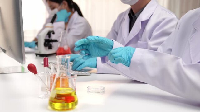 Laboratory healthcare researcher team with scientific expertise, lab equipment, and innovative medical biotechnology software in computer, research new medicines, develop cure. Slow motion. Rigid.