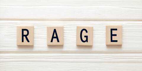 Wooden blocks spelling rage on a textured white background symbolizing human emotion, frustration, and intense anger