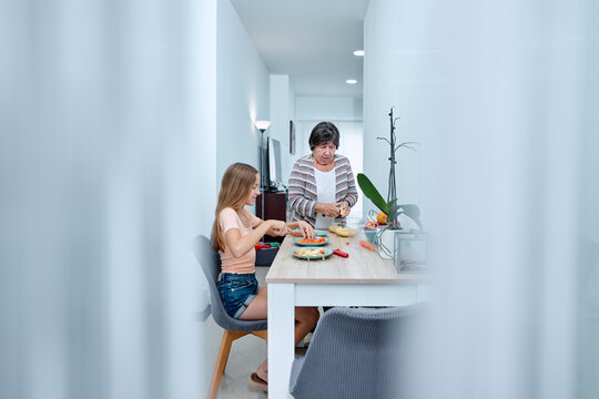 Grandmother and teenager preparing food at home