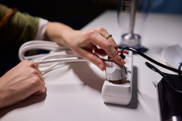 Safe plug connection demonstration, Careful connection of electrical device to power source, Demonstration of proper plugin procedure emphasizing safety and correct technique