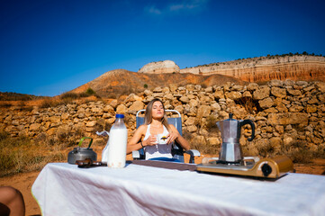 Woman savors summer coffee in the Spanish canyon beauty