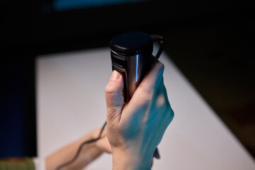 Black handheld immersion blender in professional kitchen setting, Kitchen expert demonstrating use of handheld immersion blender beside measuring tools and ingredients