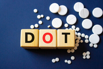 DOT symbol. Wooden cubes with words DOT Department of Transportation. Beautiful deep blue background. Healthcare and Department of Transportation concept. Copy space.
