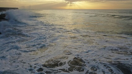 Naklejka premium I watch the waves and contemplate the sunset by the sea