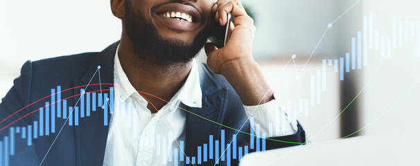 A young man in a suit happily engages in a phone call while seated in a bright office environment. The scene reflects a positive atmosphere of professional communication and collaboration.