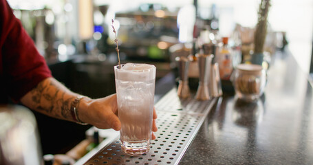 Garnishing cocktail. Ice cream soda. Barkeeper serving glass with blooming lavender branch cold water. Refreshing beverage with whipped white top.
